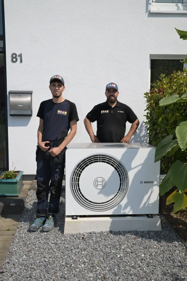 Zwei Monteure der CGT Colonia neben dem Waermepumpen-Aussengeraet